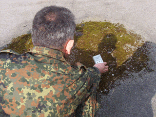 The guide, Vladimir, holds a detector over an exceptionally radioactive patch of ground. The guide, Vladimir, holds a detector over an exceptionally radioactive patch of ground.